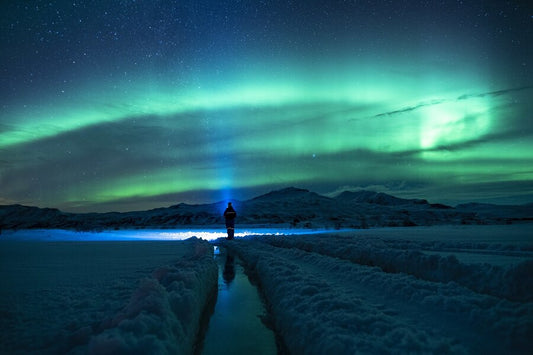 Silueta de persona apreciando el paisaje al viajar a Finlandia a ver auroras boreales